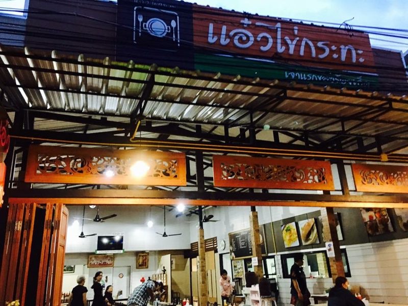 หน้าร้านยามเช้ามืด เปิดไฟสว่าง ป้ายชื่อร้านยาวเหนือชายคา